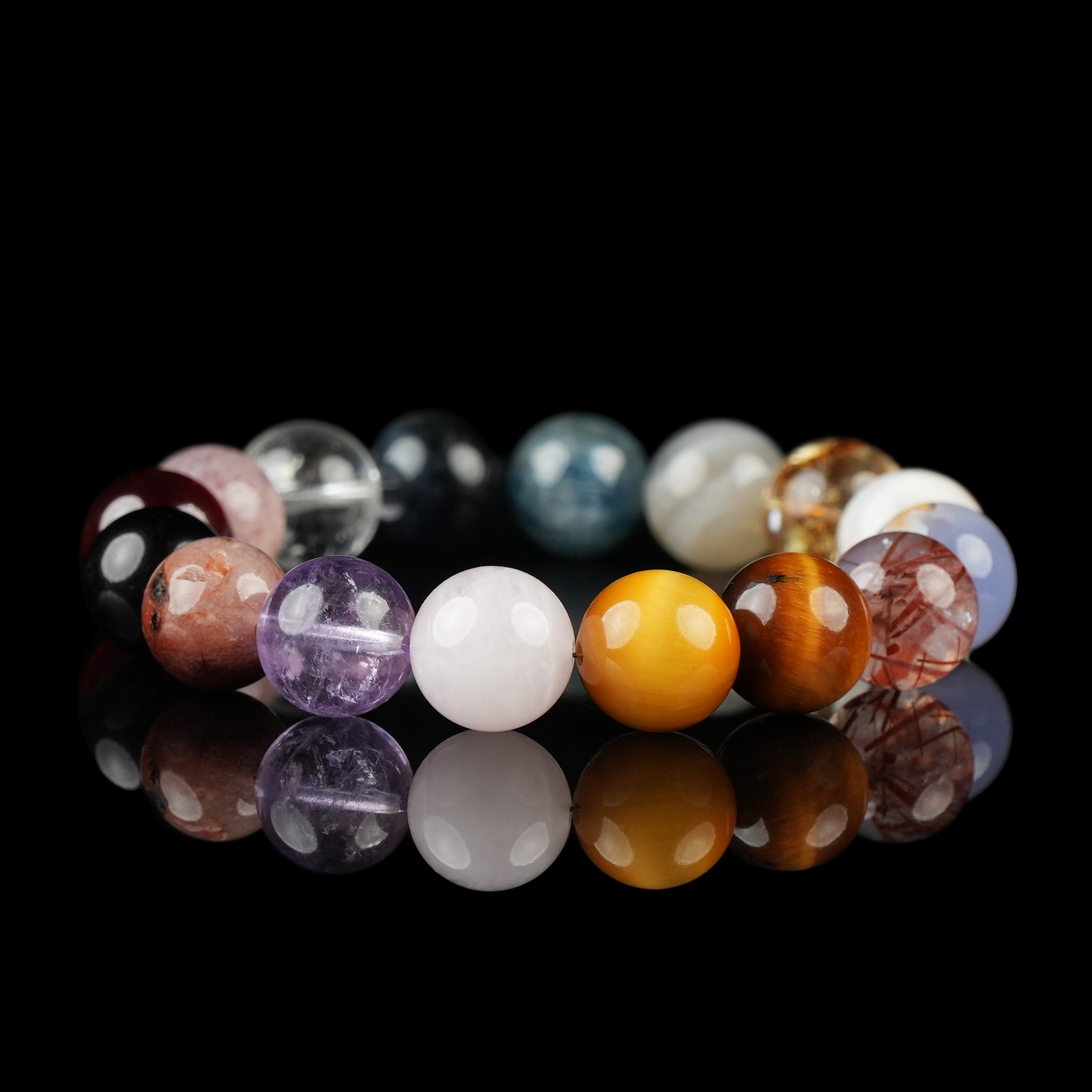 Hand holding a multi-gemstone bracelet in a circle, showcasing colorful beads like amethyst, quartz, and tiger's eye.
