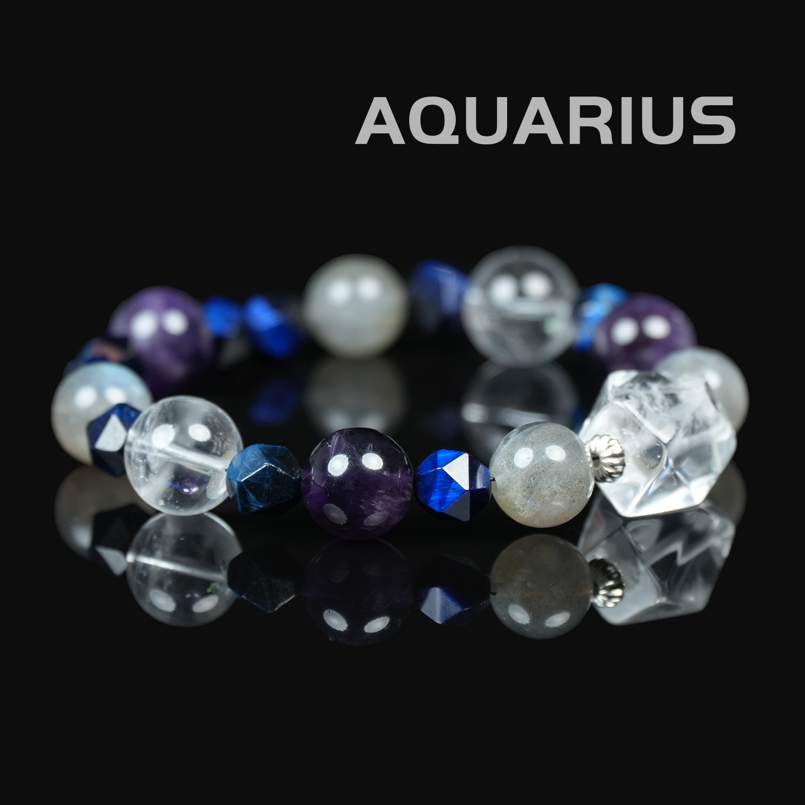Flat lay of Aquarius zodiac bracelet featuring amethyst, labradorite, clear quartz, and faceted blue crystals on black reflective background.