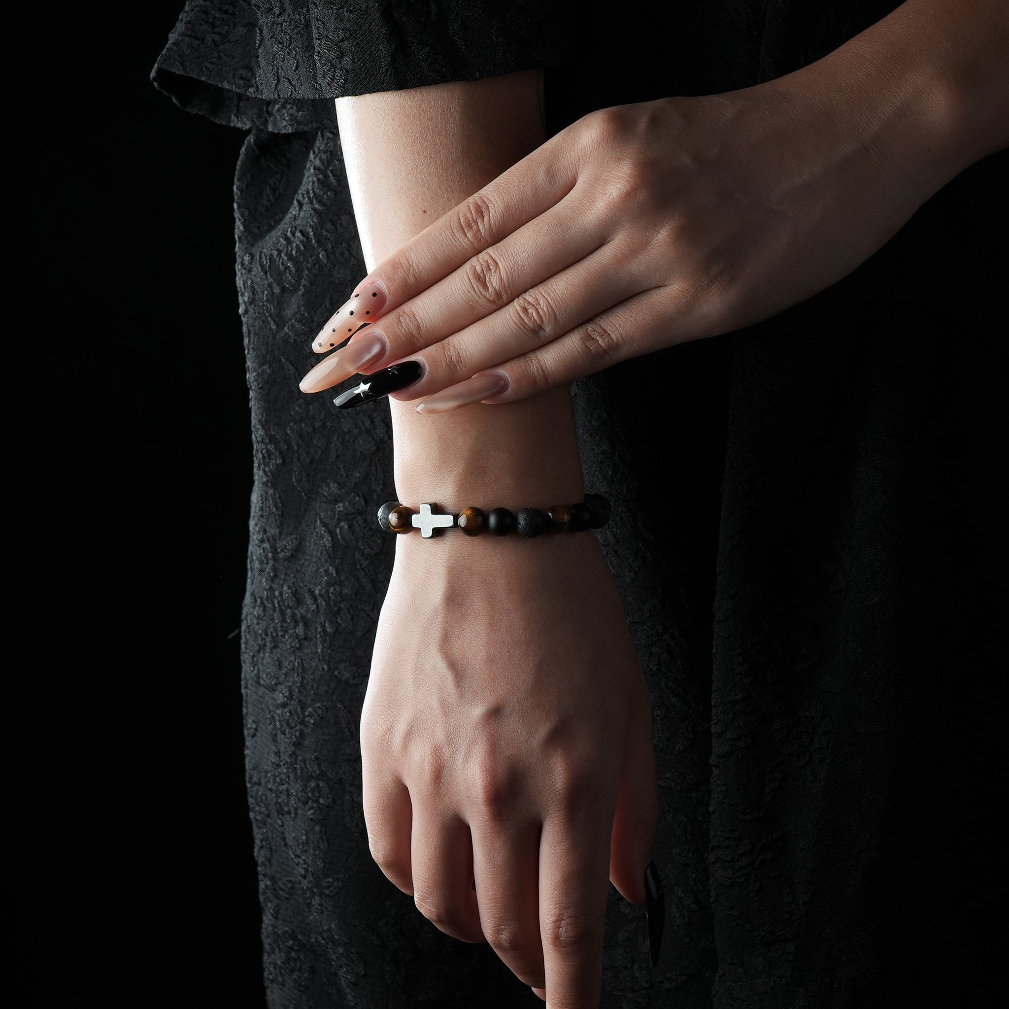 Bracelet made of Tiger’s Eye, Lava Stone, and Black Obsidian, featuring a silver cross charm.