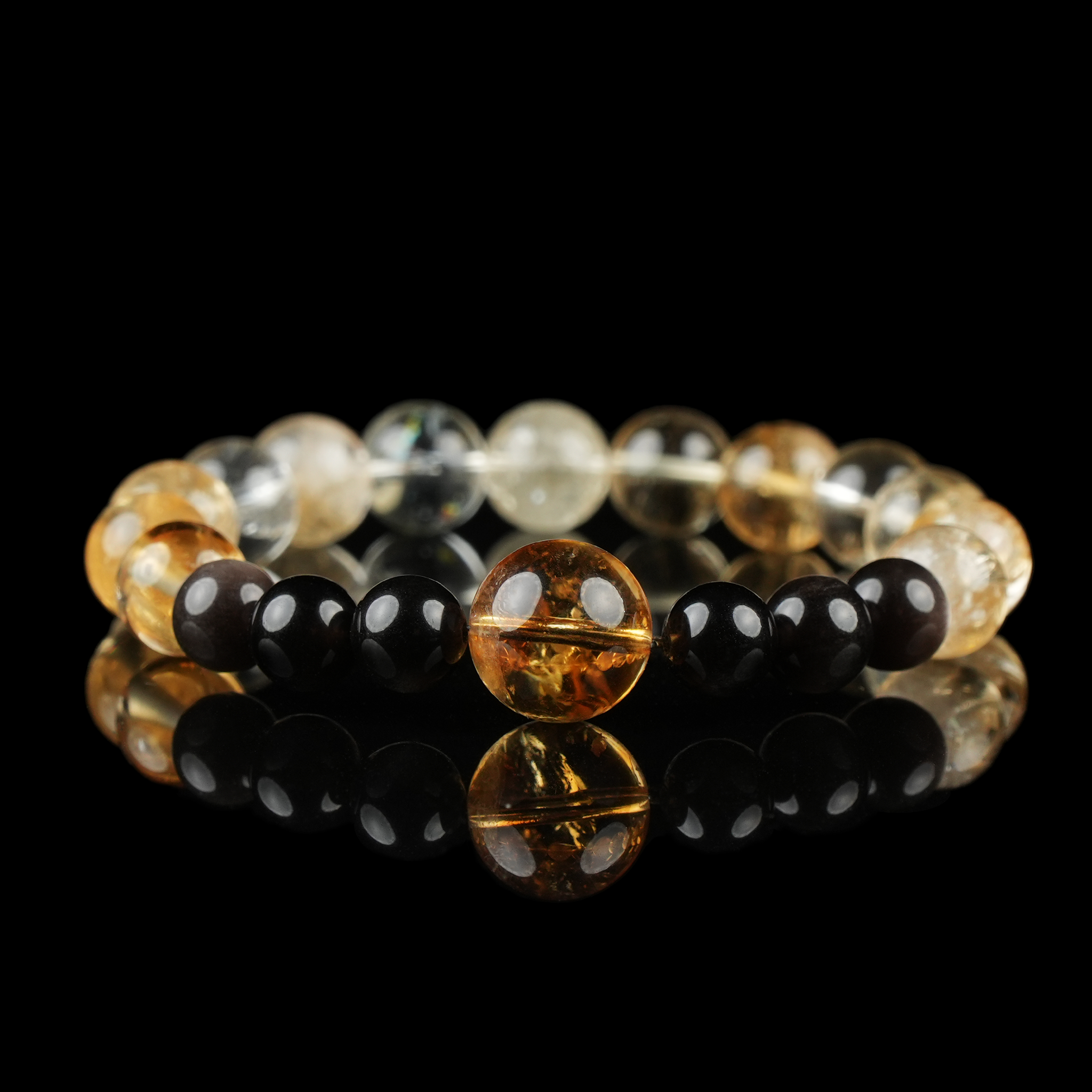A powerful energy bracelet combining golden citrine, clear quartz, and polished black obsidian beads. The vibrant yellow tones promote abundance and confidence, while the obsidian grounds and protects—ideal for those seeking motivation, wealth attraction, and energetic stability.
