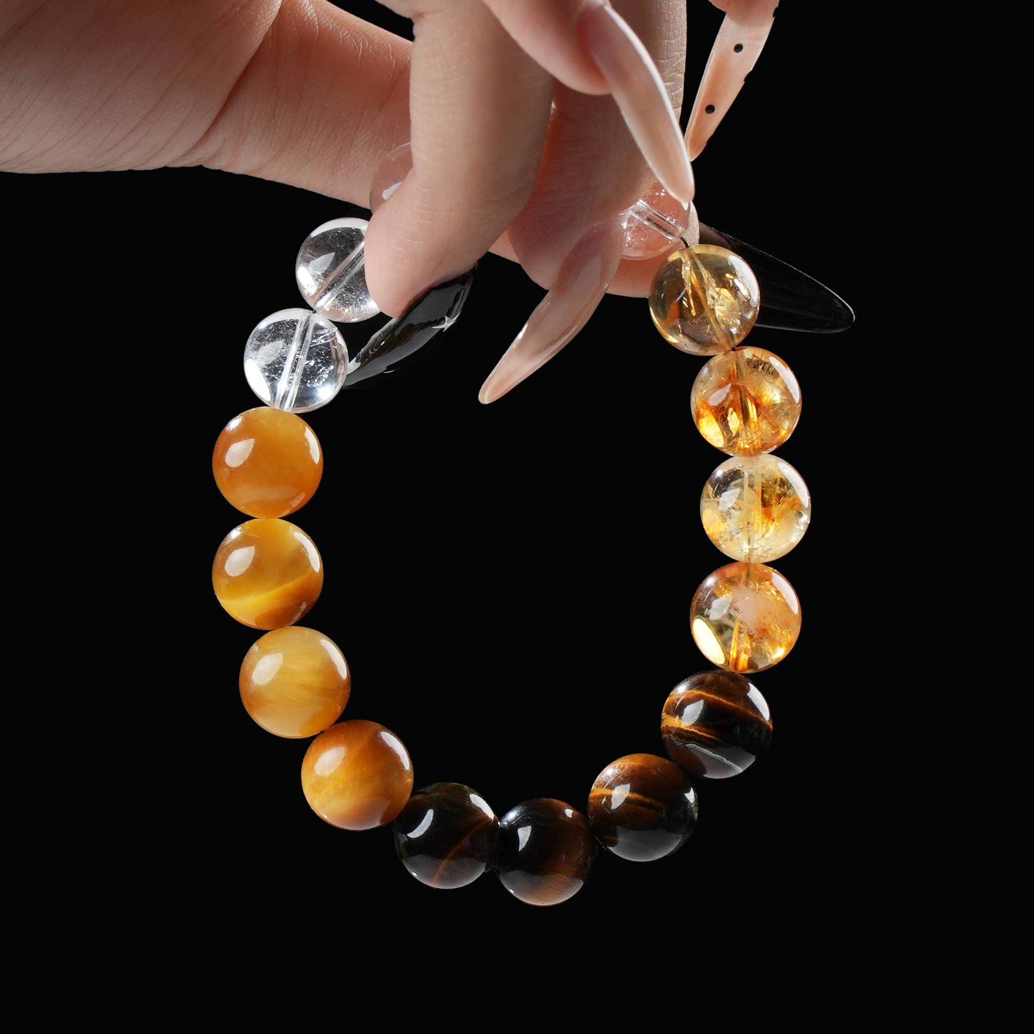 Hand holding Leo zodiac crystal bracelet with yellow citrine, brown tiger eye, and clear quartz – gemstone bracelet for vitality and courage.