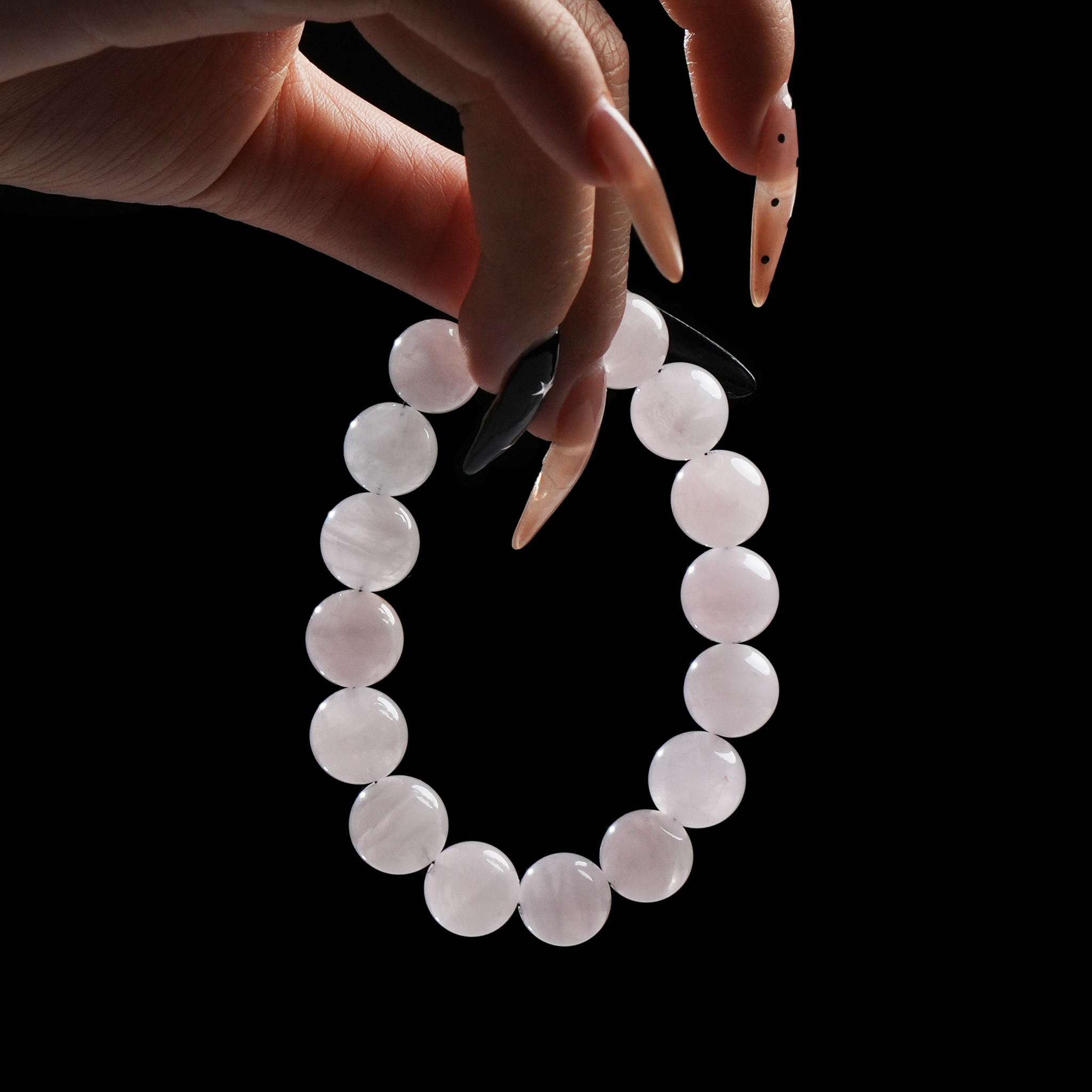 Close-up of hand holding rose quartz bracelet, known for promoting self-love and emotional healing – trending on TikTok.
