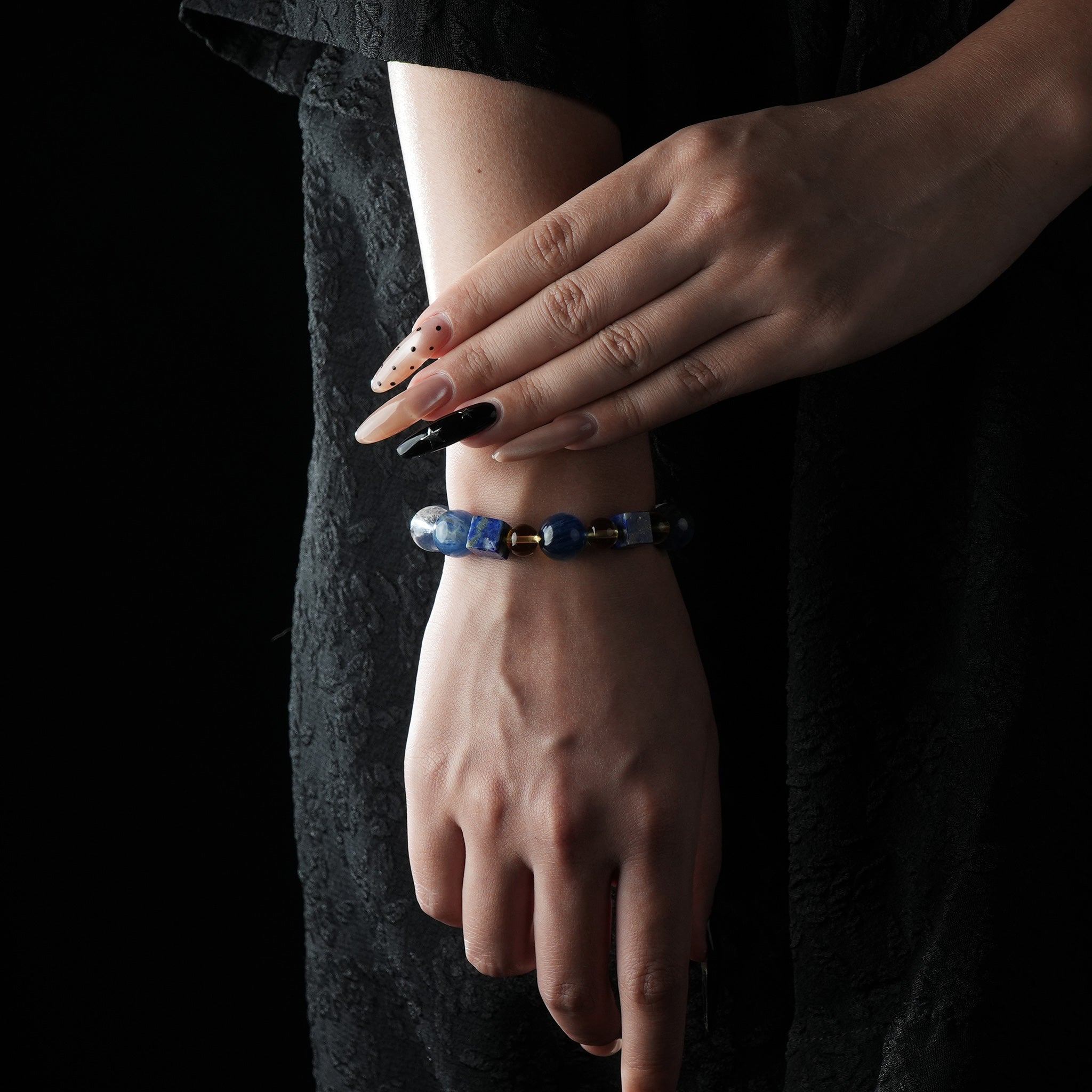 A bold bracelet featuring deep blue lapis lazuli, kyanite, and golden citrine accents, worn on the wrist.