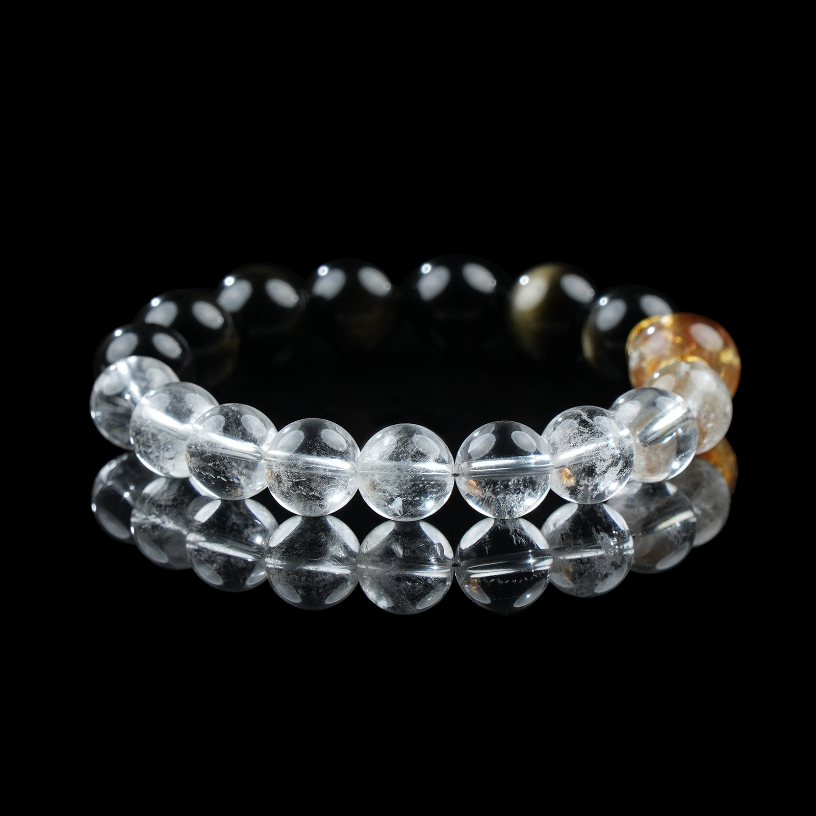 An elegant gemstone bracelet combining glossy black obsidian, clear quartz, and a central citrine bead, designed to enhance focus, protection, and prosperity.
