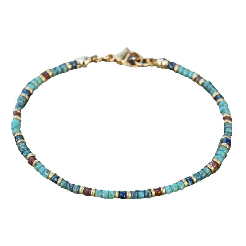 A turquoise bead anklet with gold clasp shown on a white background, highlighting its delicate structure.
