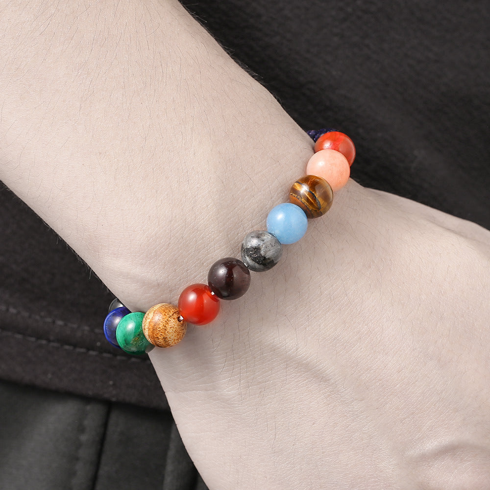 A person wearing the galaxy bracelet on the wrist, displaying the alignment of polished planet-like beads.