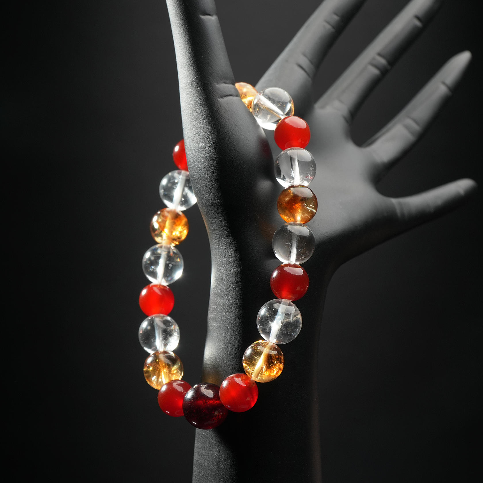 Aries crystal healing bracelet worn on hand mannequin, made with red agate, yellow citrine, and clear quartz – birthstone bracelet for Aries.