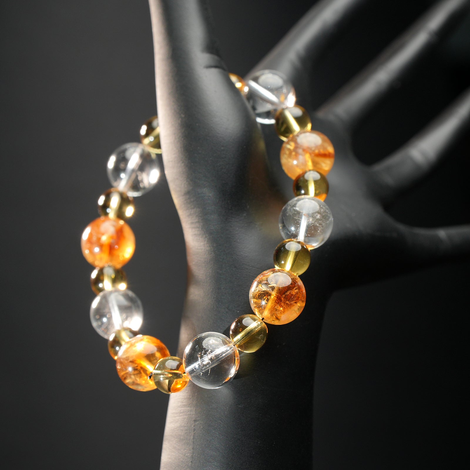Taurus astrology bracelet worn on a mannequin hand, made with golden yellow citrine, clear quartz, and golden rutilated stones for abundance and grounding.