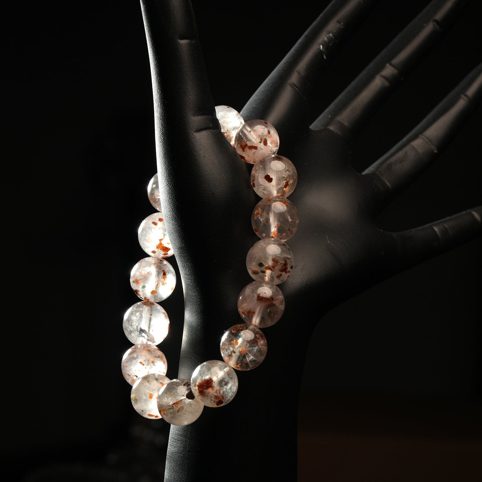 White phantom quartz bracelet worn on mannequin hand, showcasing soft internal phantoms and clear quartz for spiritual growth.