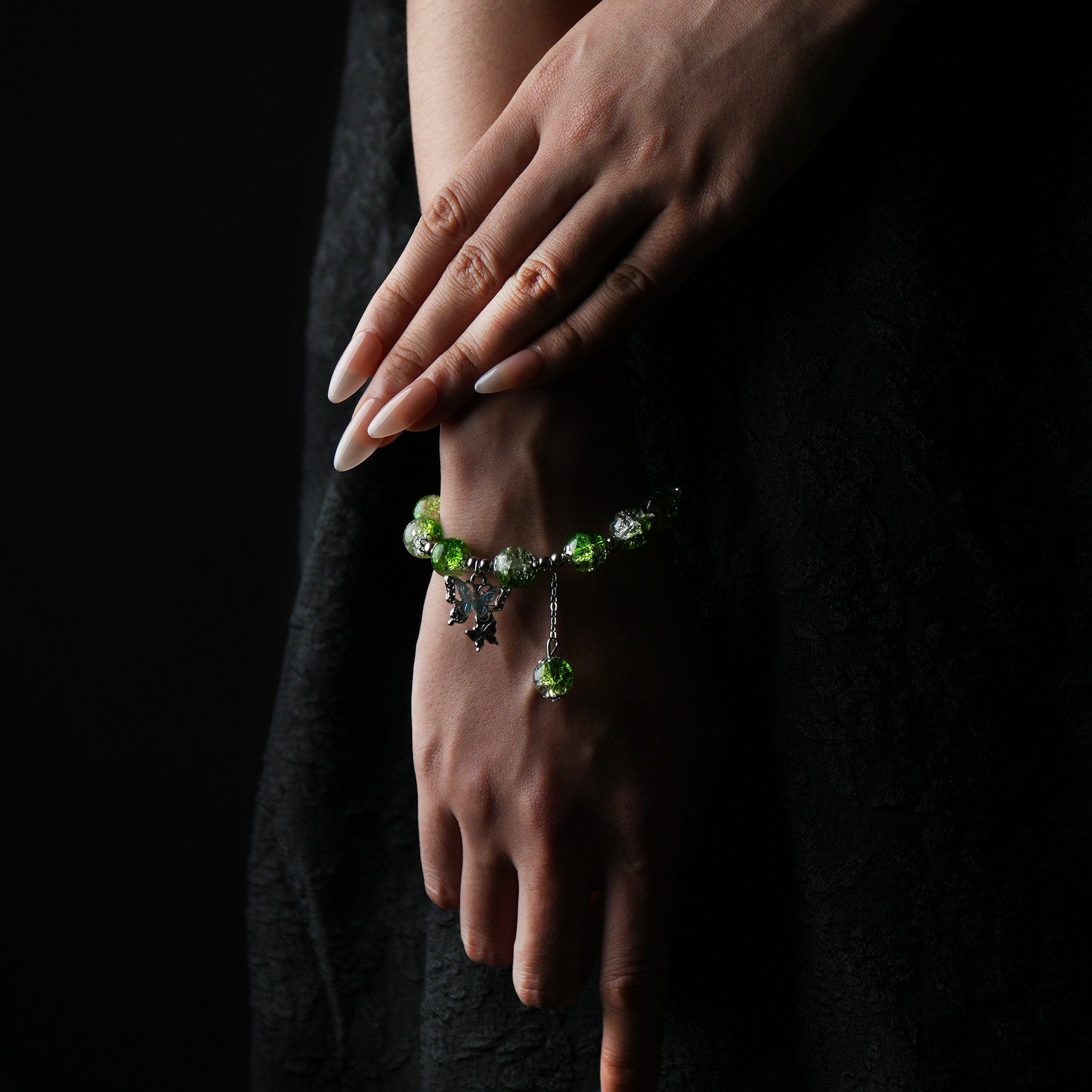 A refreshing green energy bead bracelet worn on the wrist, its translucent texture reflects light like a forest breeze, with a butterfly charm that adds a touch of spirit and vitality.