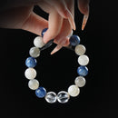 Kyanite, moonstone, labradorite, and clear quartz beaded bracelet held by hand on black background for calm, clarity, and spiritual alignment.