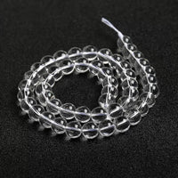 Looped natural quartz beads strung together, highlighting their uniformity and transparency.