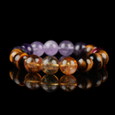 A detailed shot of a gemstone bracelet composed of radiant citrine, deep amethyst, golden tiger eye, and glossy red garnet beads, reflecting elegantly on a glossy black background
