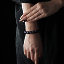 A model wearing the bracelet on the wrist, dressed in black, emphasizing the elegance and celestial glow of the Amethyst and Blue Goldstone beads against the skin.