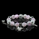 A pink and purple energy bead bracelet paired with a silver butterfly charm, glowing with a dreamy shimmer against a black backdrop.