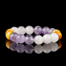 A handcrafted bracelet composed of polished amethyst, soft rose quartz, and golden yellow tiger eye beads. The natural stones are arranged in a gradient of purple, pink, and honey tones, beautifully displayed against a glossy black background.