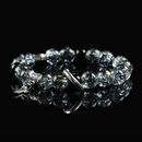 Black rutilated quartz bracelet with celestial-themed silver charms and hook clasp, displayed on reflective surface for spiritual protection.