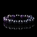 A stunning Amethyst and Blue Goldstone bracelet arranged in a perfect circle, reflecting on a black surface with a rich cosmic shimmer and deep violet hues.
