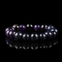 A stunning Amethyst and Blue Goldstone bracelet arranged in a perfect circle, reflecting on a black surface with a rich cosmic shimmer and deep violet hues.