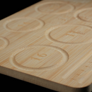 A close-up view of the circular indentations on the bamboo tray, each marked with a number indicating bead size. The clean engraving and smooth finish emphasize the tray’s utility and craftsmanship.