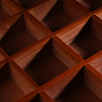 A close-up view reveals the intersections of the wooden dividers inside the organizer. The texture and joinery are clearly visible, showcasing the precision of the grid structure.
