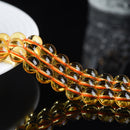 A high-resolution image showing yellow crystal beads neatly arranged on a dish, highlighting their clarity and gloss