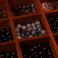 The wooden organizer is partially filled with assorted crystal beads of various colors and sizes, demonstrating how the compartments can be used for storing jewelry components or small collectibles.