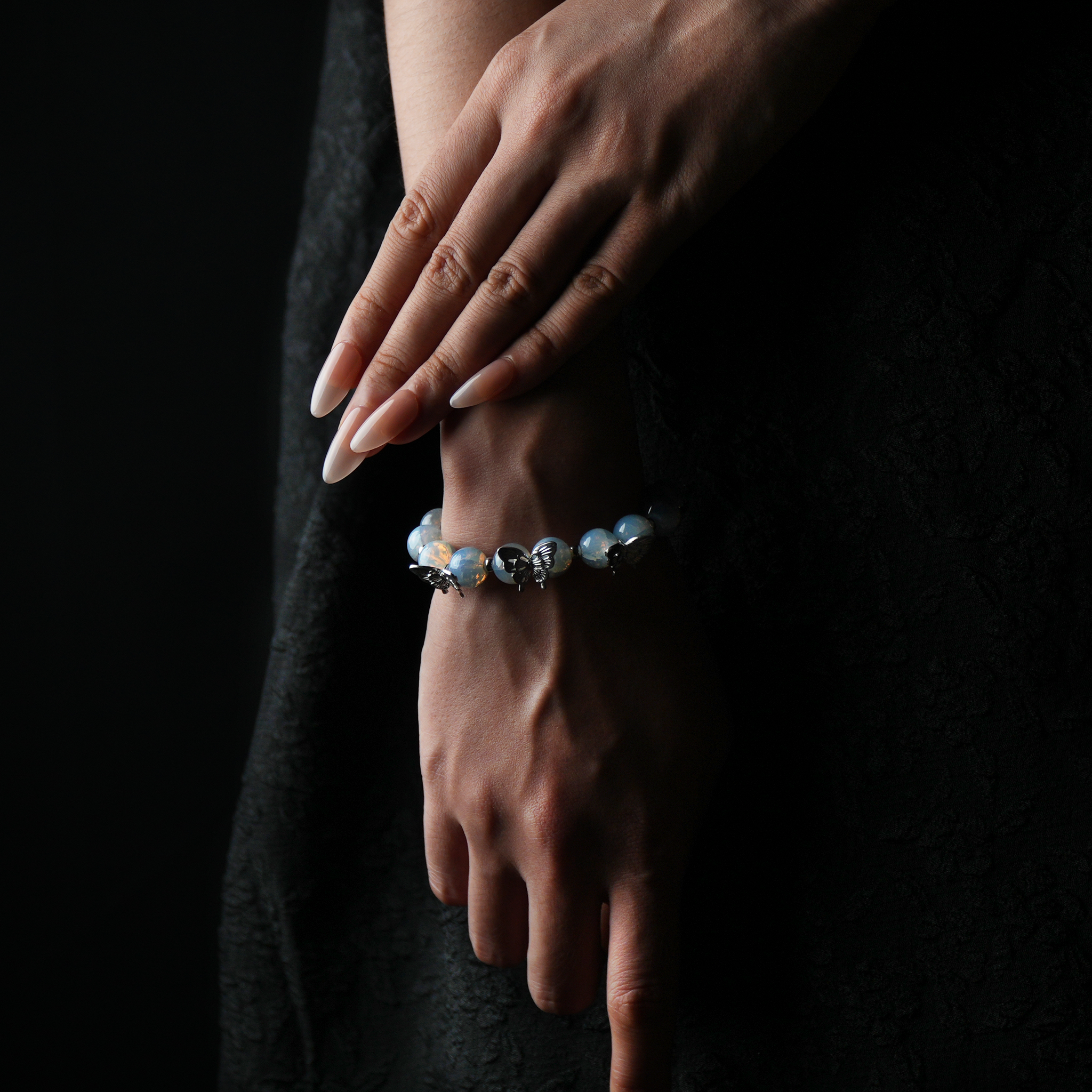 Elegant opalite butterfly bracelet shown on hand, infused with calming energy and spiritual focus, perfect for crystal healing enthusiasts.