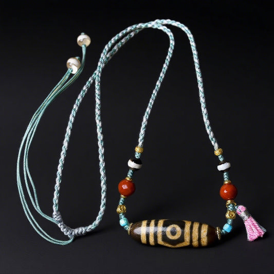 A full view of the Tibetan Agate Three-Eyed Dzi Bead Necklace, focusing on the colorful beads and adjustable cord, with a black background.