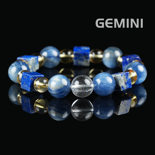 Flat lay of Gemini zodiac bracelet with deep blue lapis lazuli cubes, round kyanite beads, clear quartz, and golden citrine spacers on black reflective surface.