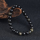 Tight shot of obsidian bracelet highlighting bead detail and subtle golden sheen, emphasizing focus, grounding, and quiet resilience.