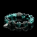 Emerald green cracked energy bead bracelet with black accent beads, silver feather charm, and chain detail, styled on a glossy black background for a bold natural look.