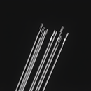 A zoomed-in shot of the needle heads, focusing on the different sizes and shapes of the eyes. The craftsmanship and polished finish of the stainless steel material are clearly visible.