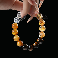 Hand holding Leo zodiac crystal bracelet with yellow citrine, brown tiger eye, and clear quartz – gemstone bracelet for vitality and courage.
