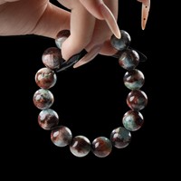 Close-up of hand holding Sagittarius birthstone bracelet with earthy red jasper and soothing amazonite beads – handmade zodiac crystal jewelry.