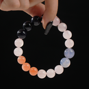 Gemstone bracelet featuring Blue Goldstone, Blue Chalcedony, Orange Moonstone, and White Chalcedony, shown against a black background.