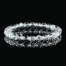 A clear quartz bracelet on a black reflective surface, highlighting the transparency and inner fractures of the crystal beads.