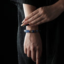 A bold bracelet featuring deep blue lapis lazuli, kyanite, and golden citrine accents, worn on the wrist.