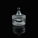 A small glass crystal charging bowl with a lid, photographed from a distance to show its elegant form.