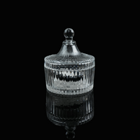 A small glass crystal charging bowl with a lid, photographed from a distance to show its elegant form.