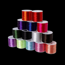 An assortment of flat elastic thread spools arranged in rows, featuring a wide variety of vibrant colors. Ideal for customized or themed jewelry projects.