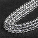 Glossy, polished white crystal beads lined up closely for display.