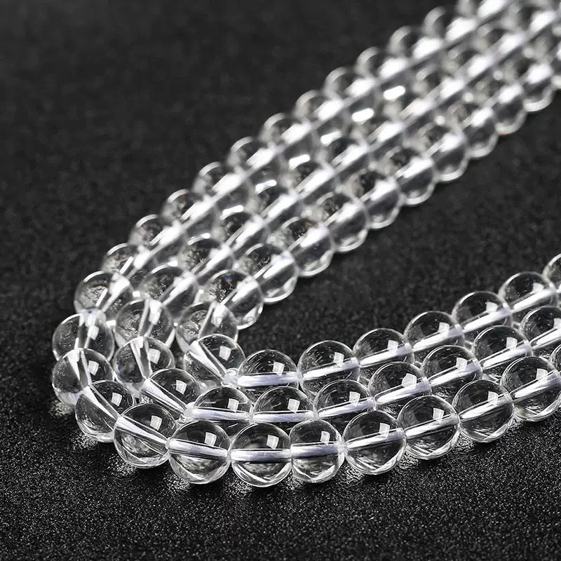 Glossy, polished white crystal beads lined up closely for display.
