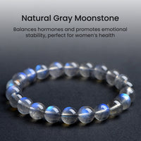 Gray moonstone bracelet with light text description, placed on a dark textured surface, highlighting the calming blue sheen typical of high-quality moonstone.