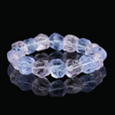 Close-up of a natural raw purple crystal bracelet, featuring irregular crystal shapes with purple hues, reflecting the light on a dark background.
