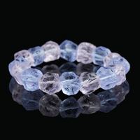 Close-up of a natural raw purple crystal bracelet, featuring irregular crystal shapes with purple hues, reflecting the light on a dark background.