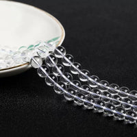 Translucent crystal beads cascading from a plate, emphasizing their round cut and high polish.