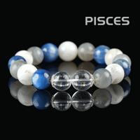 Flat lay of Pisces zodiac bracelet with blue kyanite, white moonstone, and clear quartz crystals on a black reflective background.