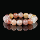 A close-up of red rutilated quartz bracelet featuring translucent beads in warm red, orange, and golden tones, symbolizing energy, clarity, and motivation.
