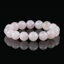 Flat lay of rose quartz crystal bracelet with soft pink polished round beads, displayed on a glossy black background.